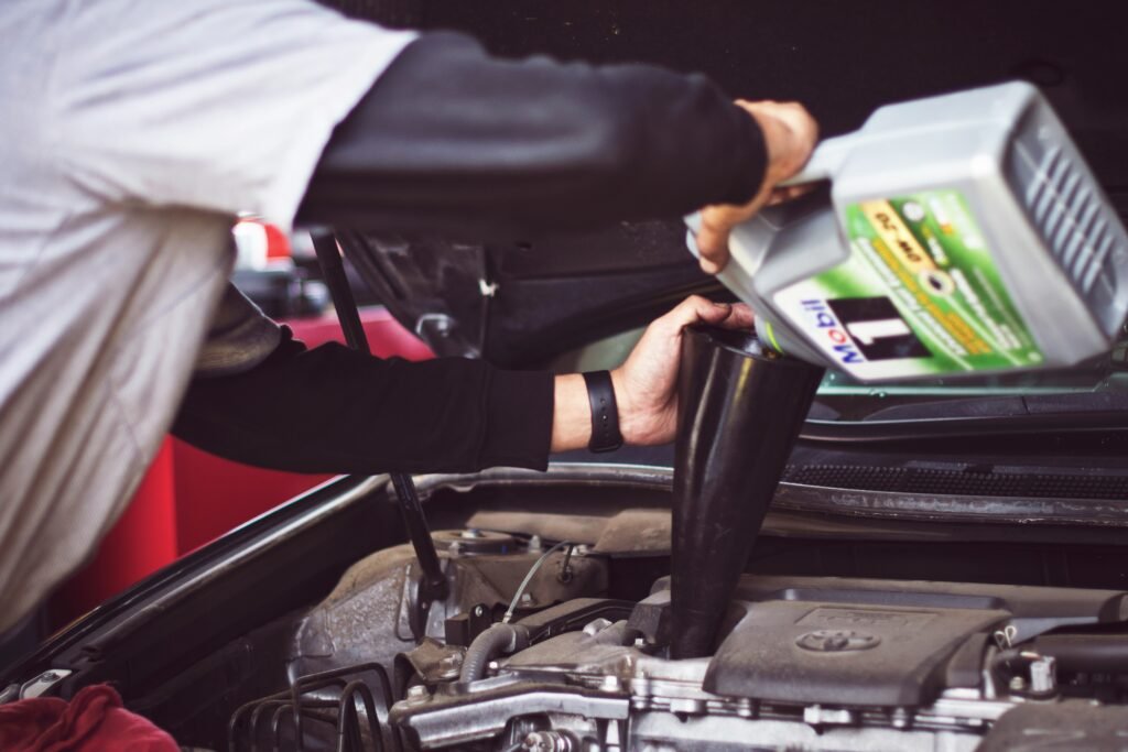 a person pouring oil into the engine